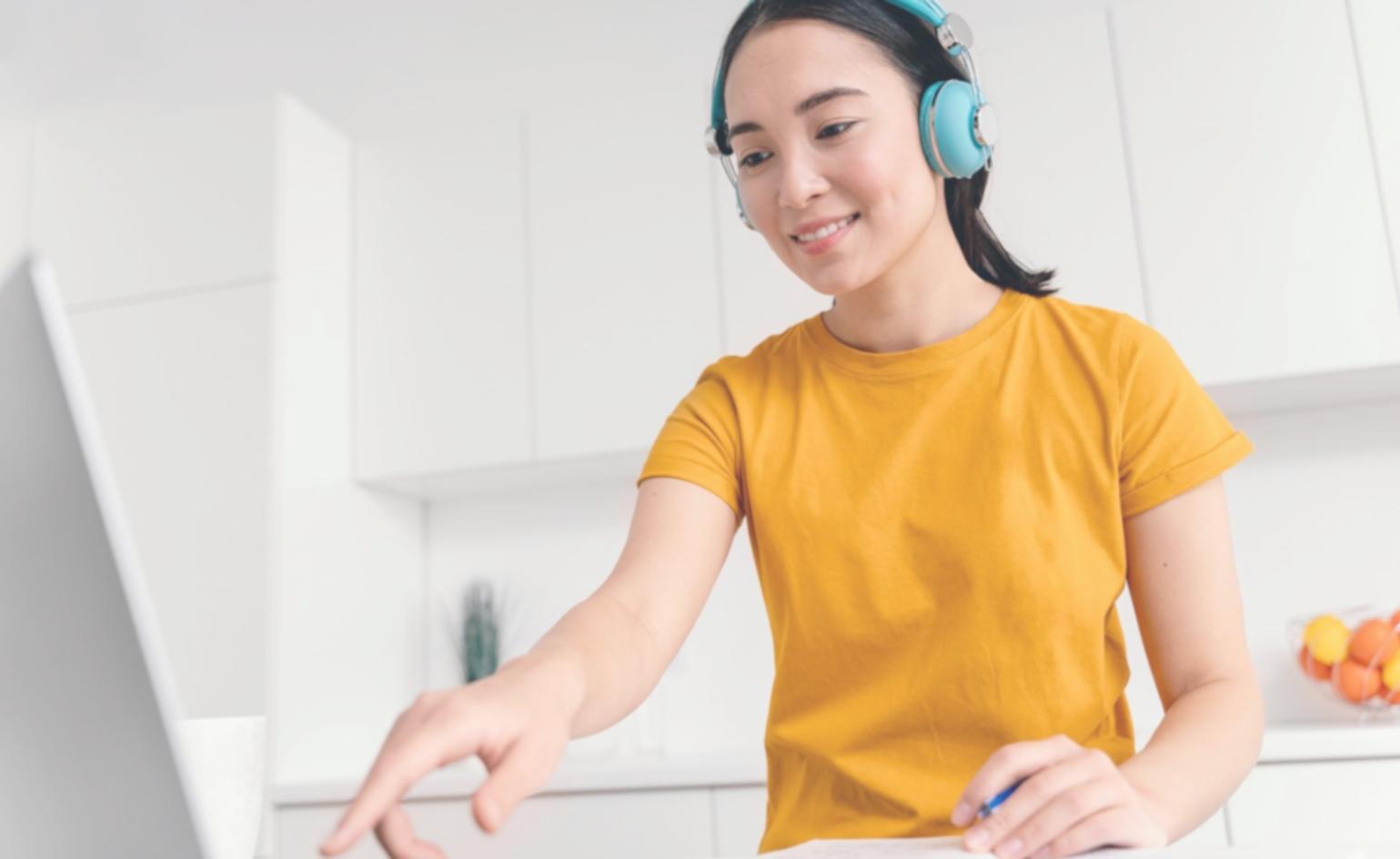 Professional woman engaged in auditory learning with headphones and audio materials